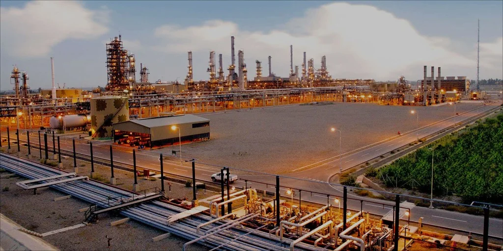 PARCO Mid-Country Refinery at Mehmood Kot — tanks and lit towers at twilight